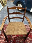 A LEATHER UPHOLSTERED ARM CHAIR, AN OAK LADDER BACKED CLISSETT TYPE ELBOW CHAIR WITH A RUSH SEAT AND