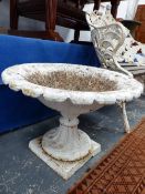 A PAIR OF WHITE PAINTED VICTORIAN CAST IRON GARDEN URNS WITH SHALLOW FLUTED BOWLS ABOVE THE SOCLES