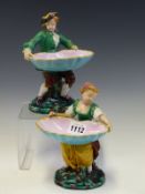 A PAIR OF MINTONS MAJOLICA FIGURAL SWEETMEATS, DATE CODE FOR 1874, THE COUPLE EACH HOLD A SHELL BOWL