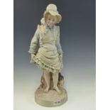 A LATE 19th C. TINTED PARIAN FIGURE OF A GIRL WITH HER SHOES OFF ABOUT TO PADDLE. H 45cms.