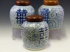 THREE SIMILAR CHINESE GINGER JARS WITH WOOD COVERS, EACH DECORATED WITH SHOU CHARACTERS ON GROUNDS