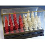 A LATE 19th C. CHINESE RED AND WHITE IVORY CHESS SET, EACH OF THE CARVED FIGURE PIECES STANDING ON A