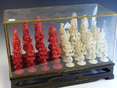 A LATE 19th C. CHINESE RED AND WHITE IVORY CHESS SET, EACH OF THE CARVED FIGURE PIECES STANDING ON A