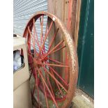 TWO LARGE PAINTED CAST IRON WAGON WHEELS.