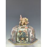 A JAPANESE IMARI DOMED HEXAGONAL COVER SURMOUNTED BY TWO GILT AND RED DETAILED LIONS PLAY