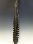 A MICRONESIAN EBONY CEREMONIAL CLUB, THE BLADE CARVED WITH SERRATED EDGES AND LANCET TIP. 69cms.