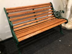A VINTAGE GARDEN BENCH WITH CAST IRON SHAPED END SUPPORTS, RECENTLY FULLY REFURBISHED WITH ENGLISH