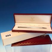 A MUST DE CARTIER, PARIS. BALL POINT PEN No. 707413 IN RED GILDED CARTIER CASE WITH PAPERS AND OUTER
