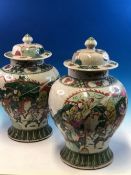 A PAIR OF CHINESE CRACKLE WARE BALUSTER JARS AND COVERS PAINTED WITH WARRIORS ON HORSEBACK AND FOOT.
