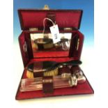 AN EARLY 20TH CENTURY RED LEATHER CASED TRAVELLING VANITY SET.