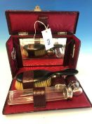 AN EARLY 20TH CENTURY RED LEATHER CASED TRAVELLING VANITY SET.