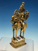 A 19th C. INDIAN POLISHED BRASS FIGURE OF SHIVA HOLDING HIS ATTRIBUTES IN HIS FOUR HANDS AS HE RIDES