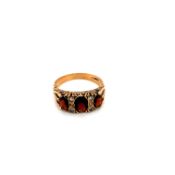 A GARNET AND CUBIC ZIRCONIA CARVED GRADUATED DRESS RING. MARKS RUBBED INSIDE SHANK, ASSESSED AS