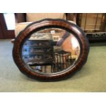 AN EARLY 20TH CENTURY OVAL WALL MIRROR IN WOOD EFFECT GESSO FRAME.