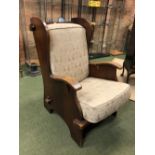 AN ARTS AND CRAFTS OAK WING ARMCHAIR CLEATS EITHER SIDE OF THE WINGS, THE SOLID SEAT AND BACK WITH