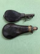 AN ANTIQUE LEATHER PERCUSSION GUN SHOT FLASK TOGETHER WITH A FURTHER ANTIQUE ADJUSTABLE MEASURE