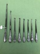 EIGHT VARIOUS ANTIQUE SILVER HANDLED STEEL BUTTON HOOKS.
