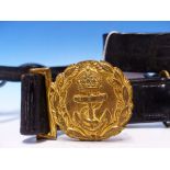 AN EARLY 20TH CENTURY ROYAL NAVY BLACK LEATHER CROSS BELT WITH GILDED CROWN ANCHOR BUCKLE.