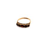 A HALLMARKED 9ct GOLD FIVE STONE GARNET GRADUATED CARVED HALF HOOP RING. FINGER SIZE T. WEIGHT 2.