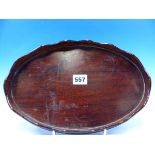 A SMALL MAHOGANY OVAL WINE TRAY WITH WAVY GALLERY EDGE 30CM LONG