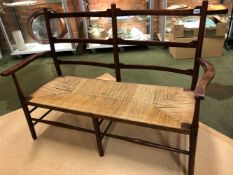 A 20th C. ARTS AND CRAFTS STAINED WOOD TWIN BAR BACK RUSH SEATED SETTEE. W 120cms.