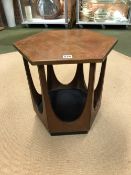 A 1970S TEAK HEXAGONAL COFFEE TABLE, THE LEGS MAKING U-SHAPES ABOVE THE LOWER EBONY TIER. W 41 x H