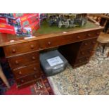 A 20th C. OAK PEDESTAL DESK WITH A GREEN LEATHER INSET TOP OVER A KNEEHOLE DRAWER FLANKED BY BANKS