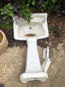 A CERAMIC WASH BASIN AND PEDESTAL.