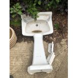 A CERAMIC WASH BASIN AND PEDESTAL.