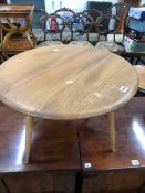 AN ERCOL TEAK FLAP TOP COFFEE TABLE, THE CIRCULAR TOP OPENING ON A SINGLE GATE. Dia. 61 x H 35.5cms.