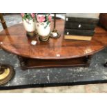 A MODERN STAINED WOOD OVAL COFFEE TABLE ON BALUSTER LEGS JOINED BY A RECTANGULAR TIER. W 150 x D