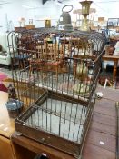 AN IRON BIRD CAGE WITH WIRE WORK SIDES ABOVE A DRAWER AND FOLIATE FEET