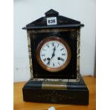 A VICTORIAN BLACK SLATE CASED CLOCK STRIKING ON A COILED ROD