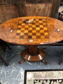 A VICTORIAN WALNUT TABLE, THE OVAL TOP INLAID WITH A CHESS BOARD ABOVE A COLUMN MEETING A DOMED OVAL