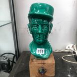 A GREEN CERAMIC BUST OF A 1ST/2ND FOREIGN CAVALRY OFFICE, THE REGIMENTAL BADGE ON THE WOOD STAND