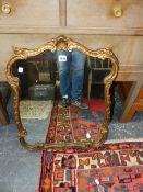 A 20th C. MIRROR IN SCROLLING GILT FOLIATE FRAME. 65 x 49cms.