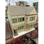 A MID 20th C. GABLE ENDED DOLLS HOUSE WITH FOUR ROOMS AND METAL WINDOWS