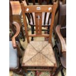 AN ARTS AND CRAFTS OAK SIDE CHAIR WITH HEART PIERCED SPLAT AND RUSH SEAT
