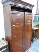 A 20th C. MAHOGANY WARD ROBE, THE DENTIL CORNICE OVER TWO PANELLED DOORS ENCLOSING SLIDES AND TWO