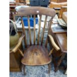 AN OAK KITCHEN ARM CHAIR WITH FOUR BAR BACK, SADDLE SEAT AND TURNED FRONT LEGS