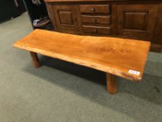 A RUSTIC HARDWOOD PIG BENCH COFFEE TABLE.