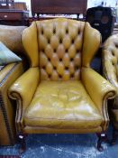 A WING ARMCHAIR BUTTON BACK UPHOLSTERED IN HONEY BROWN LEATHER