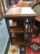 AN EDWARDIAN MAHOGANY ROTARY BOOK CASE, THE CRUCIFORM LEGS ON CASTER FEET. H 90cms W 49cms D 49cm