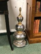 A LARGE SILVERED AND GILT DECORATED POTTERY TABLE LAMP.