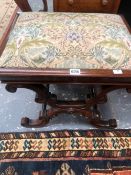 A VICTORIAN ROSEWOOD STOOL, THE DROP IN SEAT ABOVE CRUCIFORM LEGS ON THE BROAD SIDES JOINED BY TWO