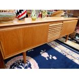 A 1970S TEAK SIDEBOARD WITH THE THREE CENTRAL DRAWERS FLANKED BY PULL DOWN CUPBOARDS. W 209 x D 45 x