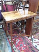 AN EDWARDIAN SATIN WOOD BANDED AND CONCH SHELL INLAID MAHOGANY SWIVEL TOP GAMES TABLE ON LINE INLAID