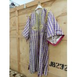 A MIDDLE EASTERN OPEN FRONTED KAFTAN IN ALTERNATING PURPLE AND CREAM STRIPED MATERIAL.