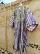 A MIDDLE EASTERN OPEN FRONTED KAFTAN IN ALTERNATING PURPLE AND CREAM STRIPED MATERIAL.