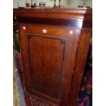 A GEORGE III OAK CORNER CUPBOARD, THE DOOR CENTRED BY A VASE OF FLOWERS OVAL WITHIN MAHOGANY CROSS
